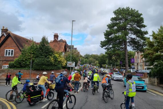 Photo of many children and adults cycling along the road in Guildford. There is a mass of cyclists going up the hill as far as the eye can see.